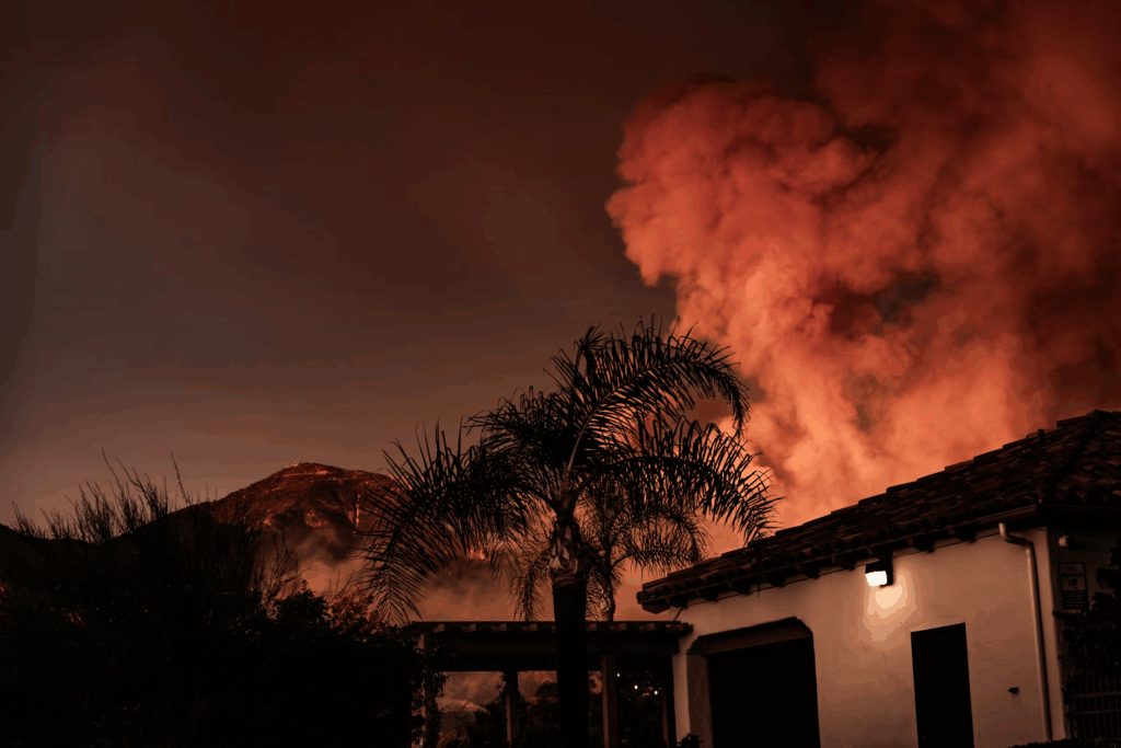 plume of smoke rising behind house from wildfire effecting California air quality