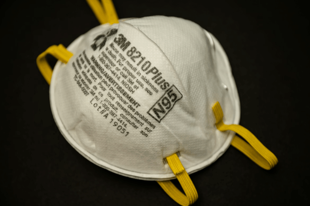 N95 mask made by 3M with yellow bands against black background