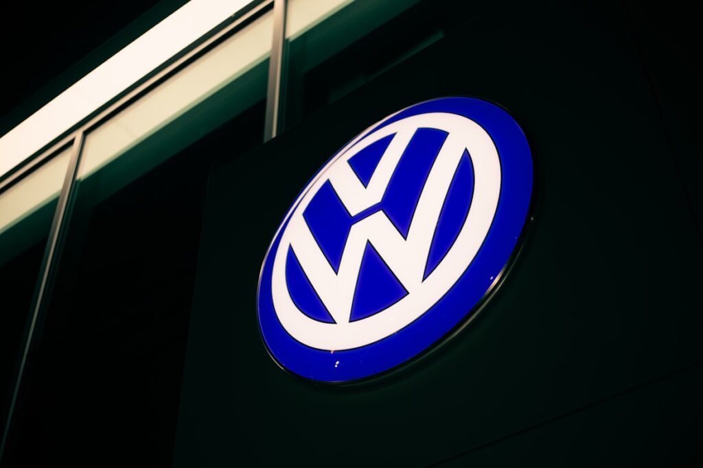 Illuminated Volkswagen logo in blue and white against a dark background.