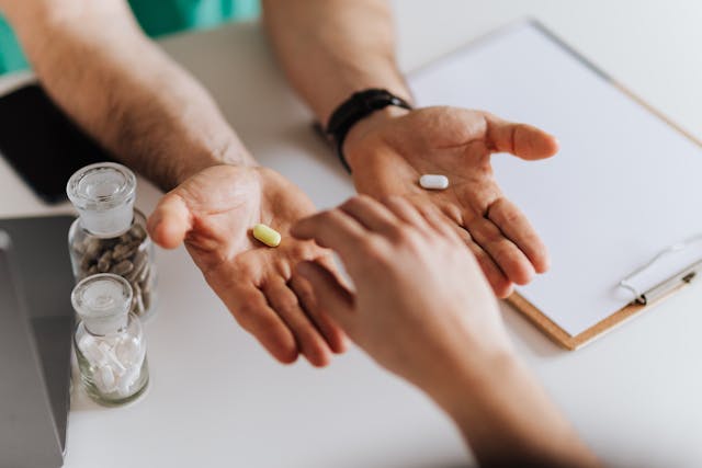 man taking pill from doctor's hand