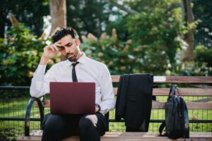 15+ boring $120-an-hour jobs employers are desperate to fill A Man in a White Long Sleeves and Black Pants Using His Laptop While Sitting on a Brown Wooden Bench