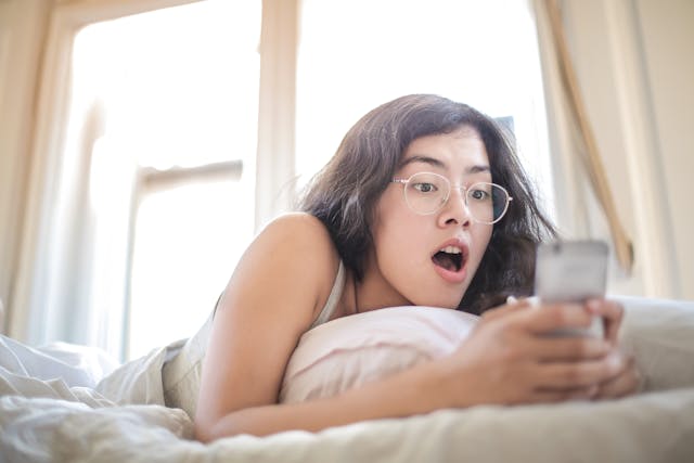 woman on phone in bed