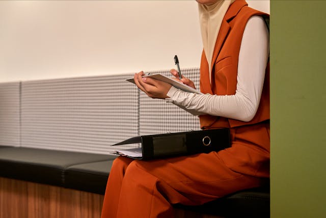 woman sitting on bench working