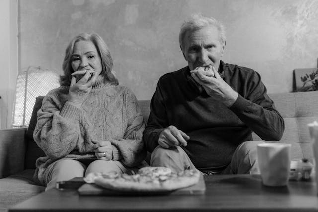Elderly couple eating pizza