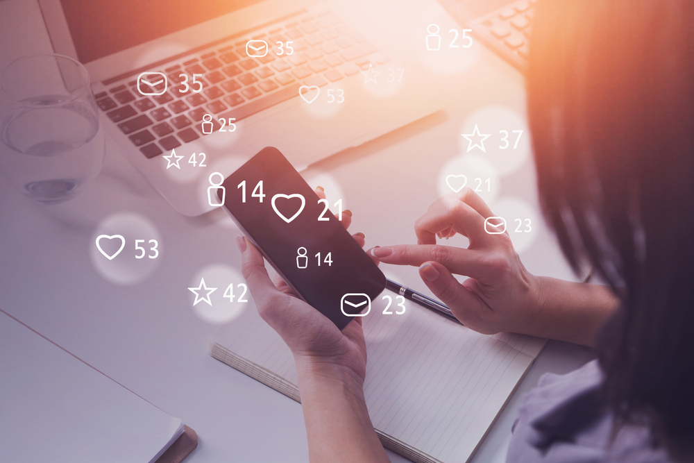 Top view of young woman using smartphone with double exposure of social media interface. Toned image