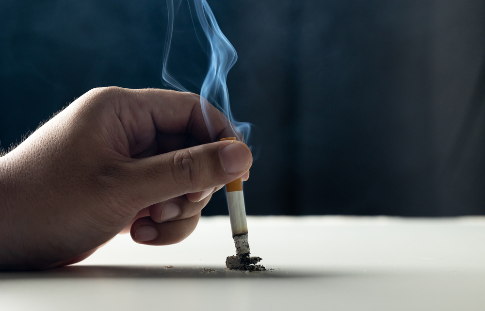 Close up hand putting out a cigarette. man extinguished his cigarette by crushing the floor. He smoked a lot of cigarettes