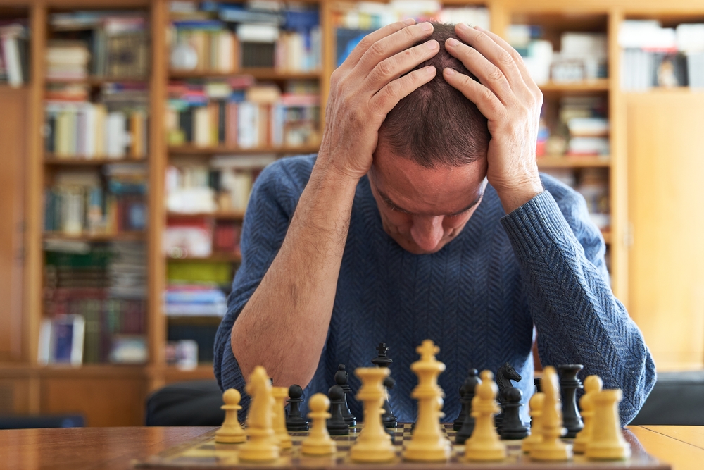 Memory loss and Alzheimer problem. Senior man devastated over chess board