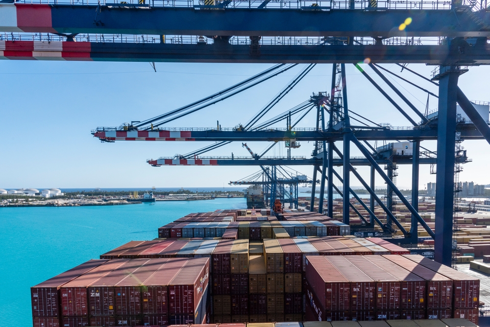 Freeport, Bahamas - April 15, 2023: View of full containers on the deck of a cargo ship. It is referred to below under gantry cranes for loading and unloading cargo on its international route.  