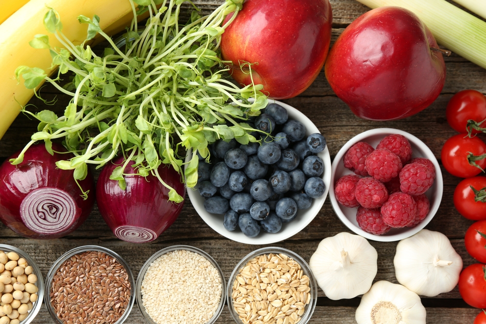 Different fresh products on wooden table, flat lay. Source of prebiotics