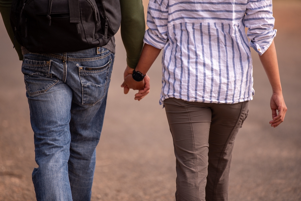 Two people holding hands, fingers gently intertwined, symbolising connection, trust, love, and support. A tender gesture of closeness, warmth, companionship, unity, and emotional bonding.