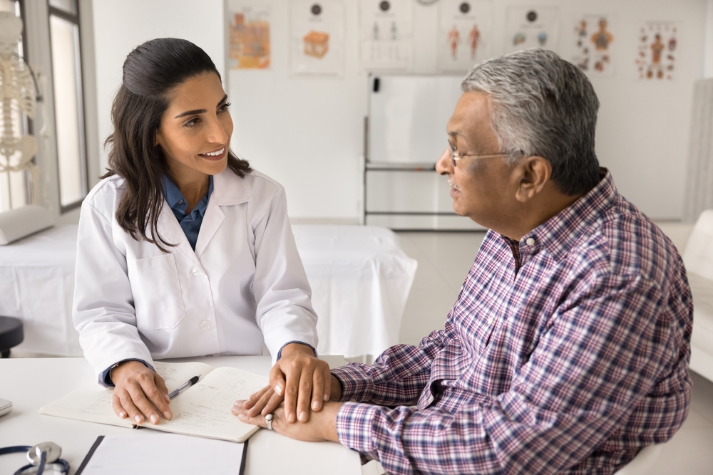 Believe me. Smiling compassionate female doctor therapist surgeon comfort senior age male patient on appointment in clinic touch hand support in struggle with disease reassure in optimistic prognosis