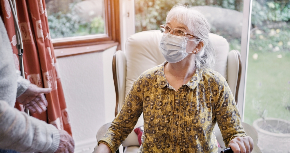 Senior, woman and living room or mask virus for protection or husband, compliance for health care. Old people, pandemic management for illness cooperation in home for marriage, empathy or quarantine