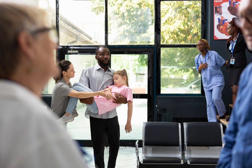 Young kid faints in her father arms with worried mother by her side, as african american team provides first aid and assistance during pediatric emergency and family health scare.