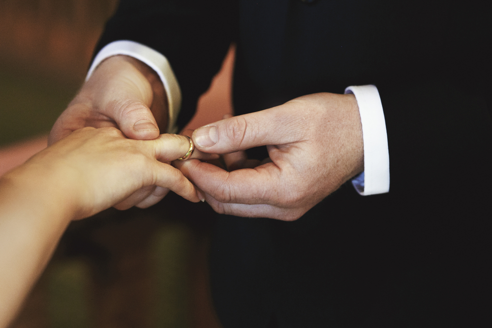 Bride and groom hands on the wedding ceremony indoors