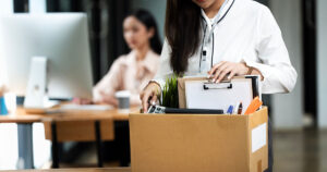 Major Companies Cutting Jobs This Year: Verizon, IBM, Amazon, Starbucks, American Airlines, and Others Woman with her office belongings in a box