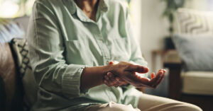 These Unexpected Rheumatoid Arthritis Symptoms Could Be Easy to Miss Mature, woman and hand with wrist pain, muscle ache or tension for rheumatoid arthritis. Inflammation, osteoporosis or carpal tunnel syndrome with circulation issue, joint strain or swollen at home