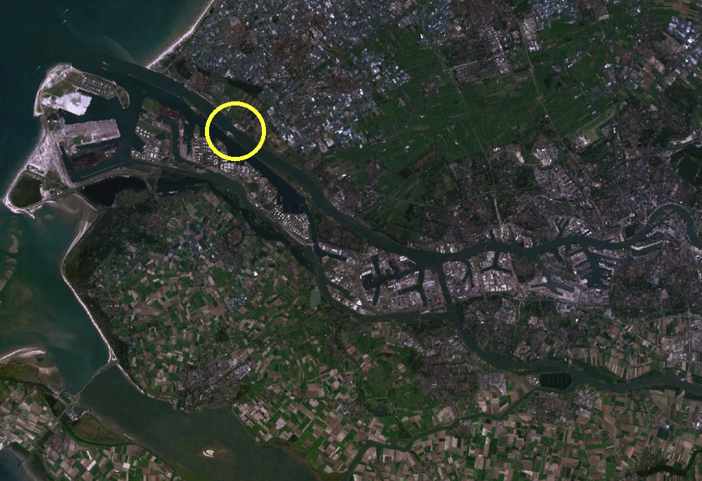 Satellite image of the Rotterdam port area and river delta, with a yellow circle marking the location of flood defense infrastructure where waterways meet the North Sea.