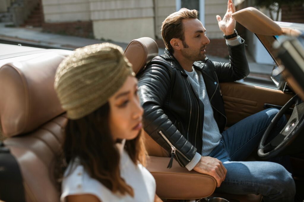 A Man In A Black Leather Jacket Sits Next To A Woman Having An Argument