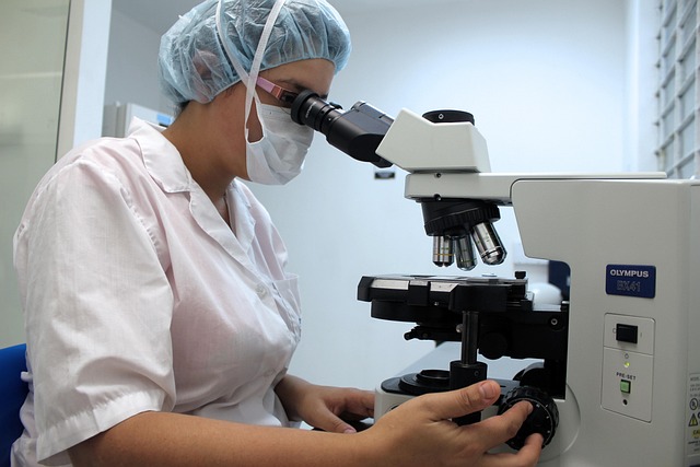 researcher looking through microscope