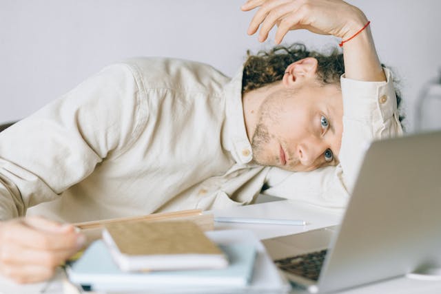 man tired in front of laptop