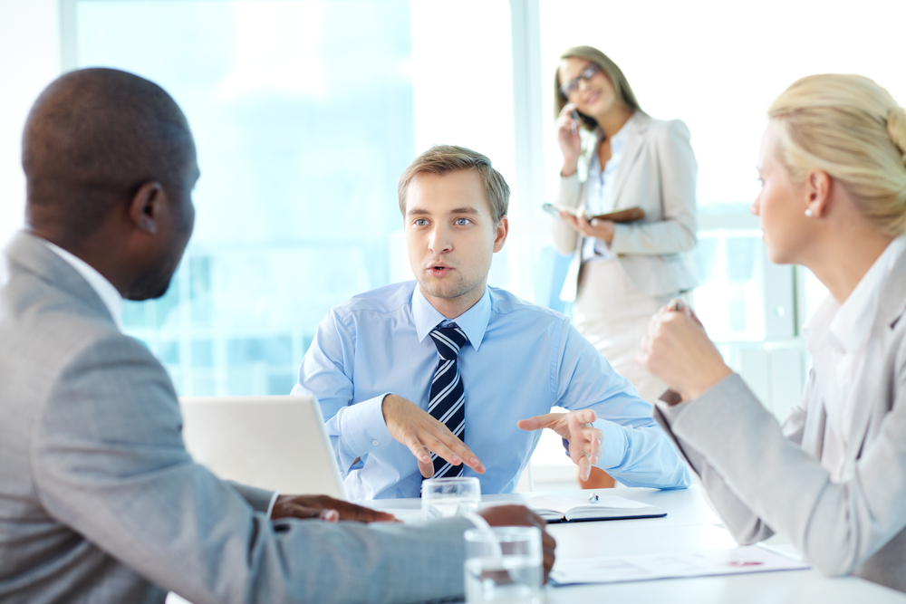 Portrait of confident boss explaining strategy to his partners at meeting