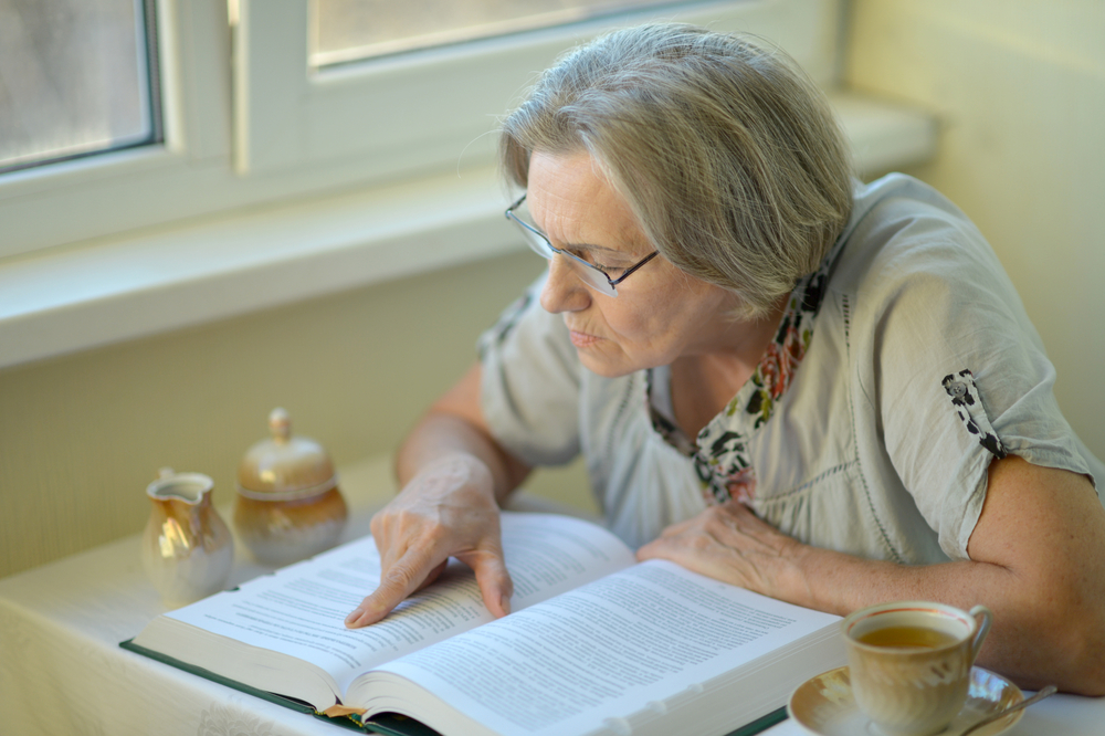 Nice woman is reading book at home