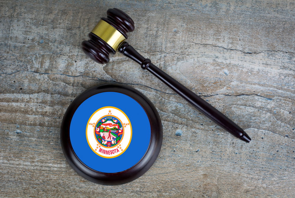 Wooden judgement or auction mallet with of Minnesota flag. Conceptual image.