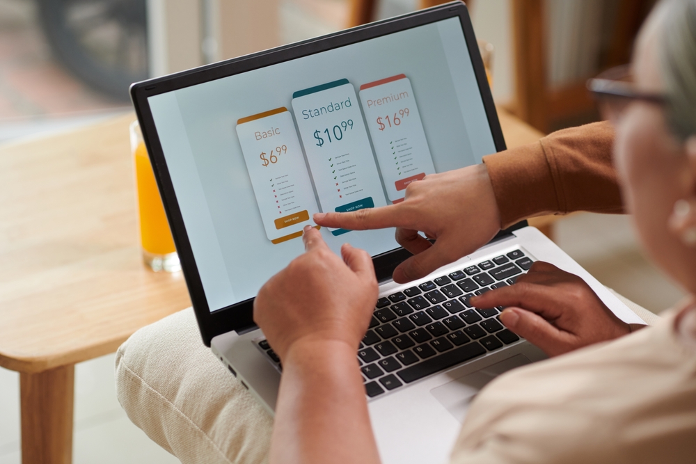 Closeup image of teenage boy explaining grandmother how to pay for online service subscription