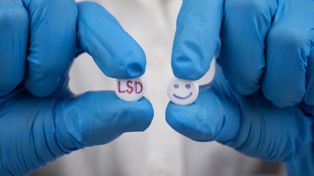 green and red LSD pills in the hands of a doctor, a psychedelic drug for treating severe stages of depression.