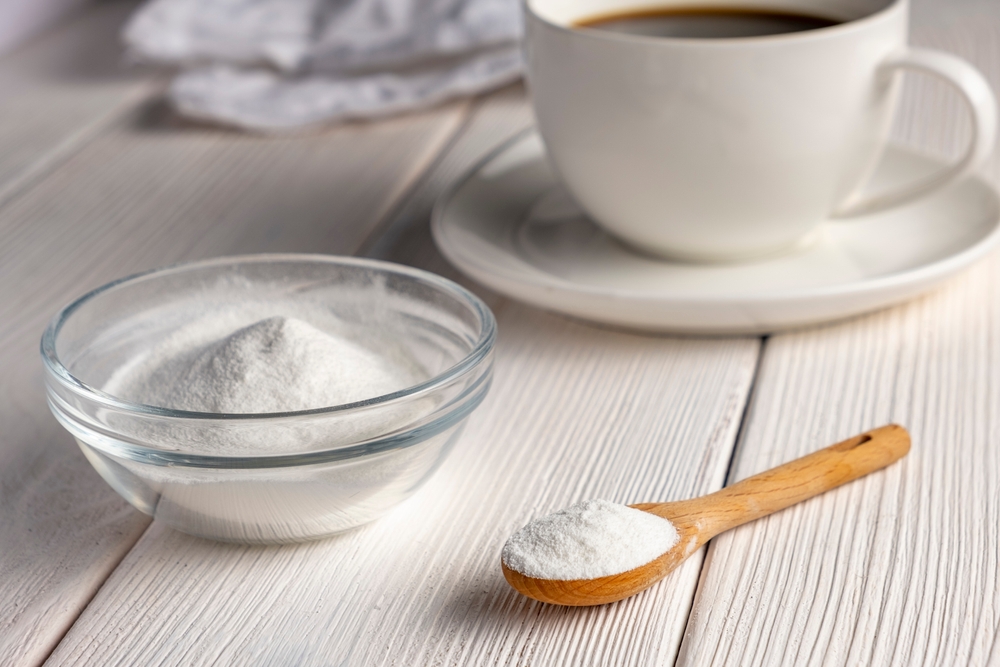 Herbal sweetener stevia in a spoon and a cup of coffee.