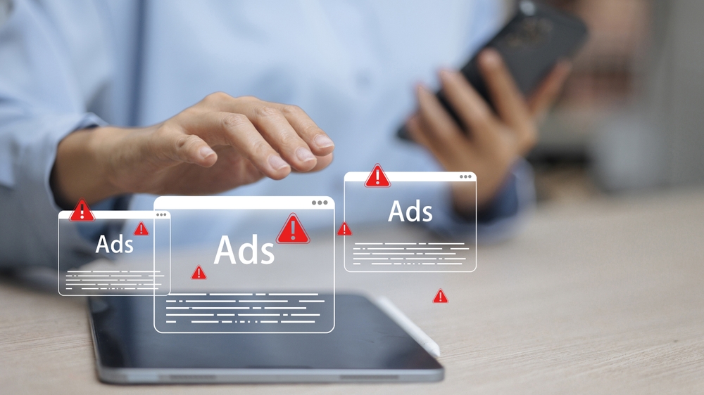 Close up hand using tablet with multiple ads warning popups, online advertising alert, digital marketing risk, internet spam notification concept.