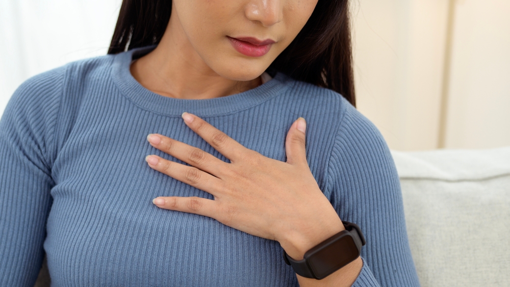 A young woman doing a breast exam at home, Cancer Awareness
