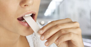 woman putting piece of gum in her mouth