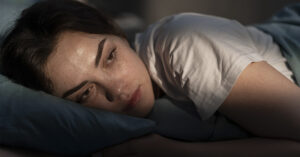The One Night Time Disorder That Increases Your Dementia Risk by 50% - And What To Do About It woman in bed, laying awake at night