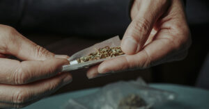 close up of person rolling a marijuana cigarette or joint