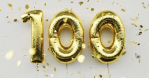 gold-colored foil balloons shaped as the number 100, likely used for celebrating a 100th birthday