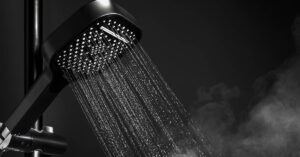 Can 'Dark Showering' Actually Improve Sleep? The Viral Trend Explained Shower head with running water. Close up in darker room. Dark showering concept