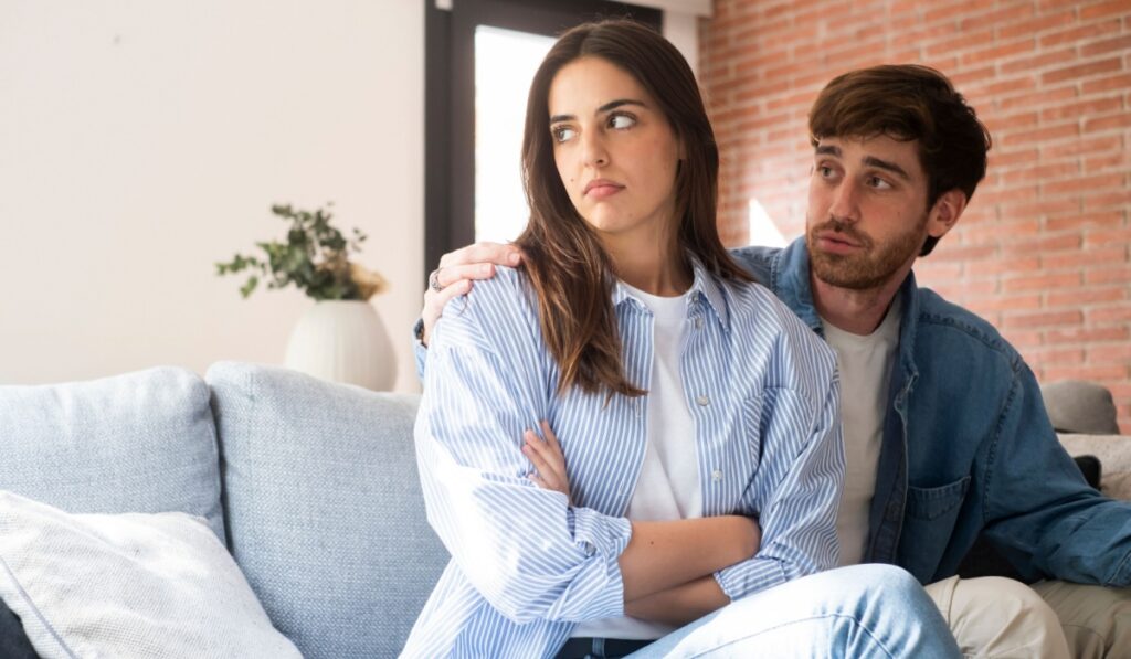 A dramatic moment of relationship breakdown between a young couple, as the offended girlfriend ignores her partner's emotional attempts to explain himself.
