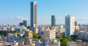 Live Large in Europe: 10 Cities Where Your Money Goes a Long Way Nicosia cityscape with a mix of modern high-rise buildings and older shorter structures. Skyscrapers and more traditional building highlights urban development and architectural city diversity