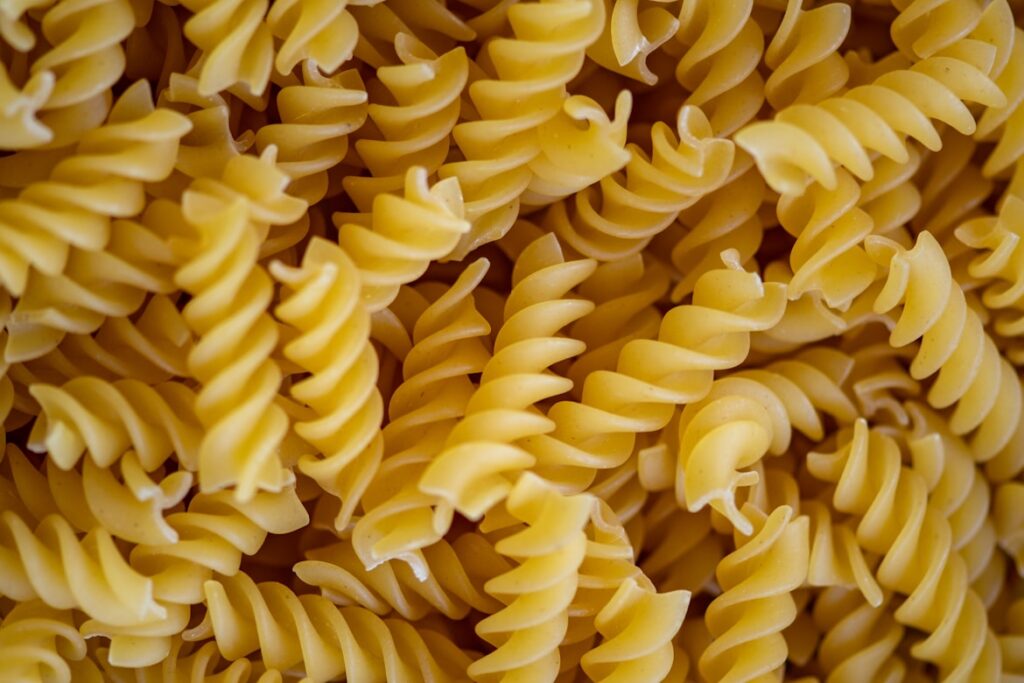 Close-up of dried yellow fusilli pasta spirals filling the entire frame.