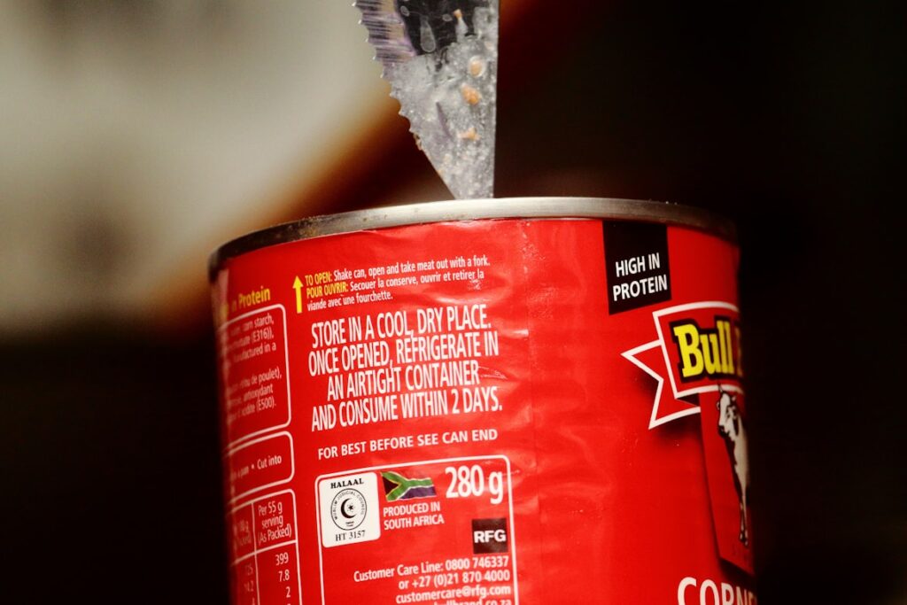 Close-up of a red food can with storage instructions printed on the label, including text about refrigerating after opening and consuming within 2 days.