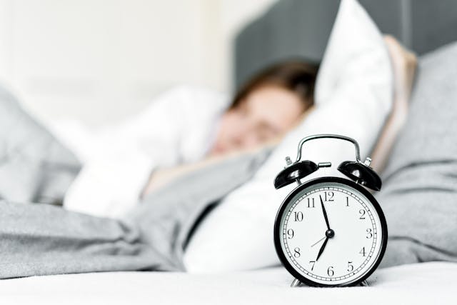 clock next to woman sleeping