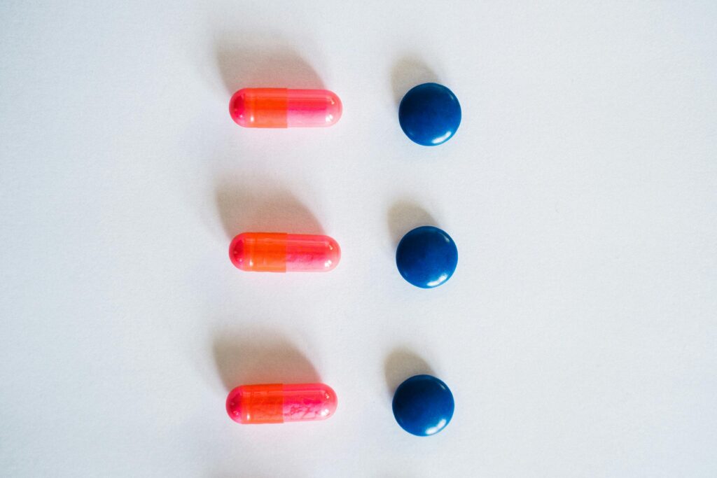 A Pink and Blue Pills on White Surface