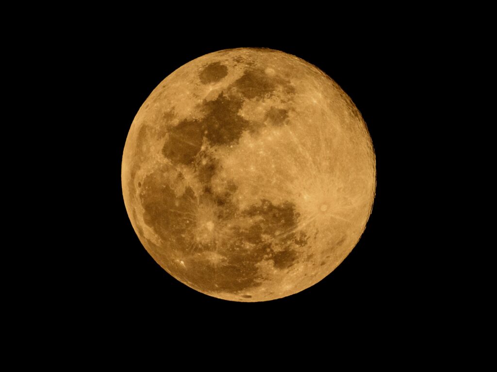 Golden Full Moon Against Black Night Sky
