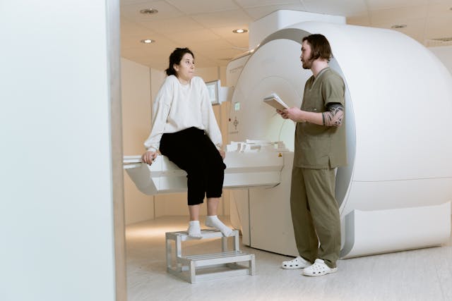 doctor talking to woman by MRI machine