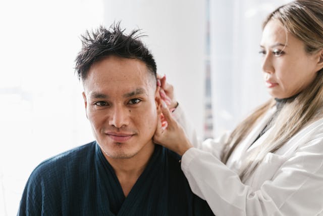 doctor looking at the ear of a patient