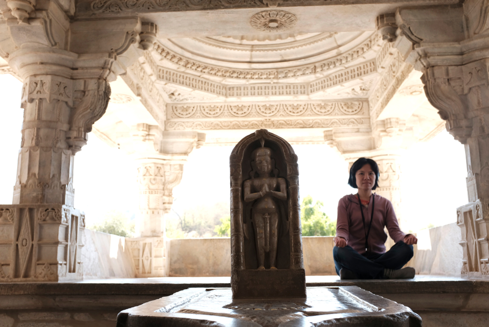 Ranakpur Jain Temple, Rajasthan, India - January 2019 : A woman meditating inside the Ranakpur Jain Temple, Rajasthan, India.