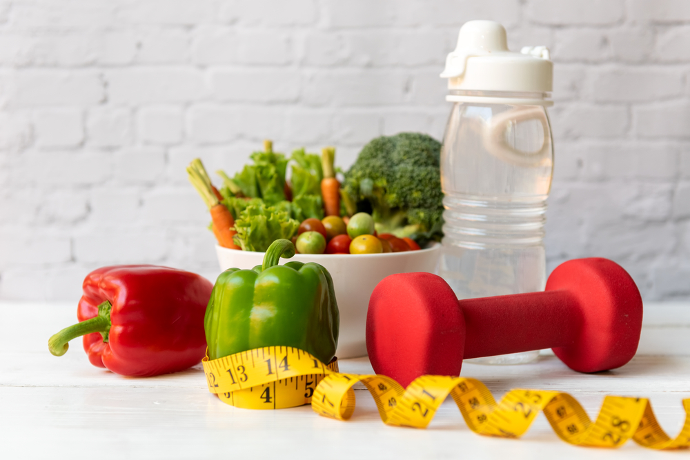 Diet Healthy food and lifestyle health concept. Sport exercise equipment workout and gym background with nutrition detox salad for fitness style. Healthy Concept