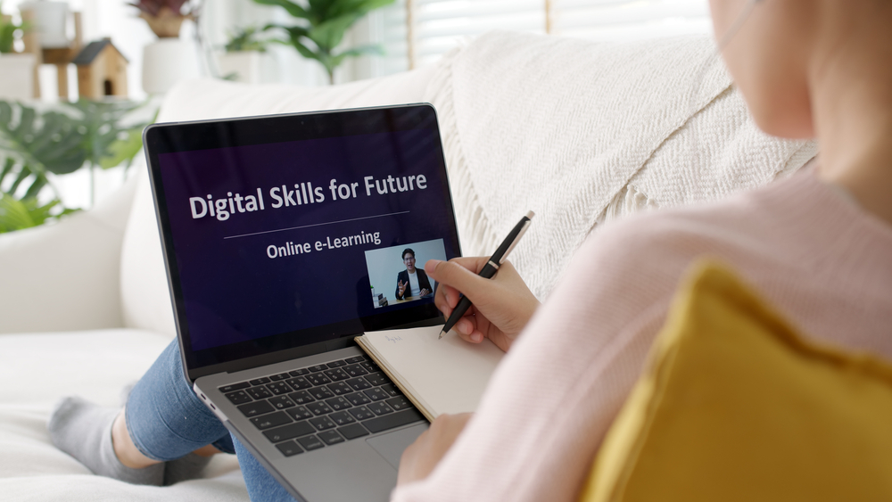 Rear view young asian woman listen watch digital class e-learning online for employee reskill upskill on notebook computer at home office workplace. Business school lesson education for adult people.