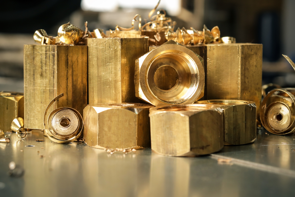 Hexagonal bars and brass products made on CNC metalworking machines. Manufacturing of parts from brass. Close-up.